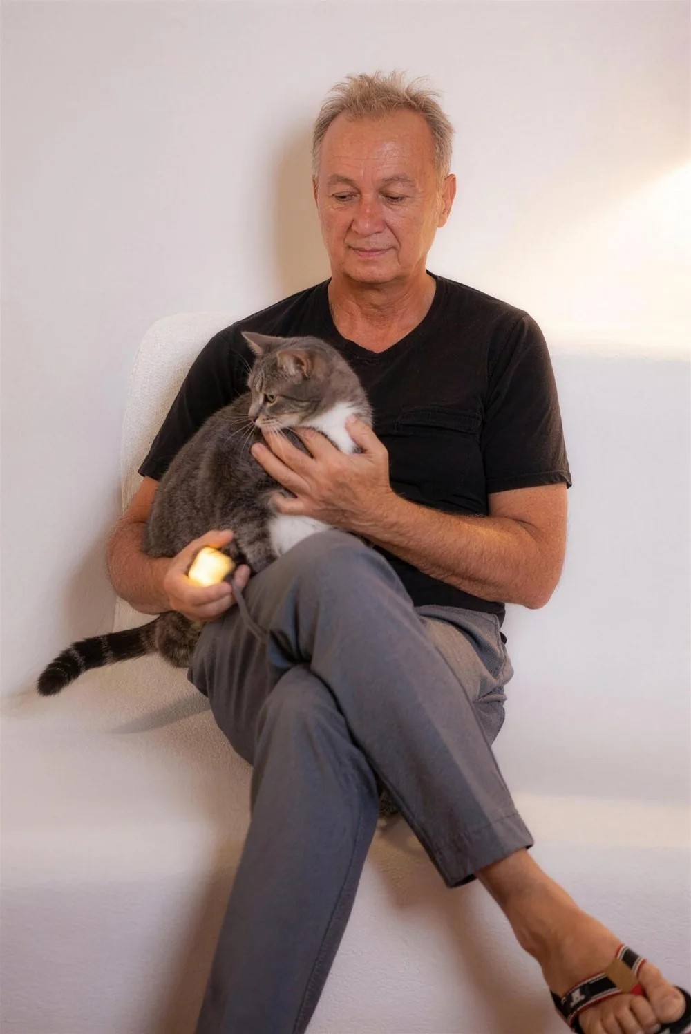 Un homme apaise son chat, le dispositif ZenSpire Pets dans la main