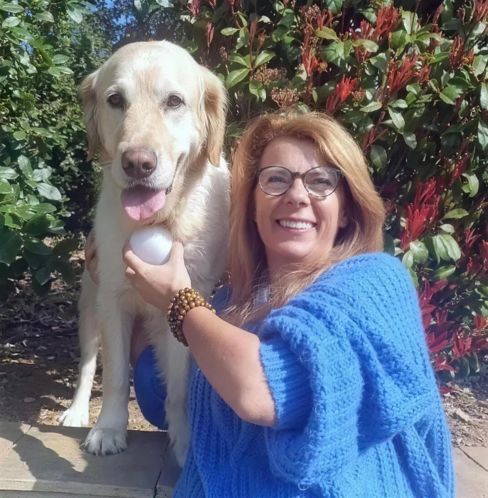 Shaïna Lebeau, communicatrice animale, avec un golden retriever et le dispositif ZenSpire Pets dans la main